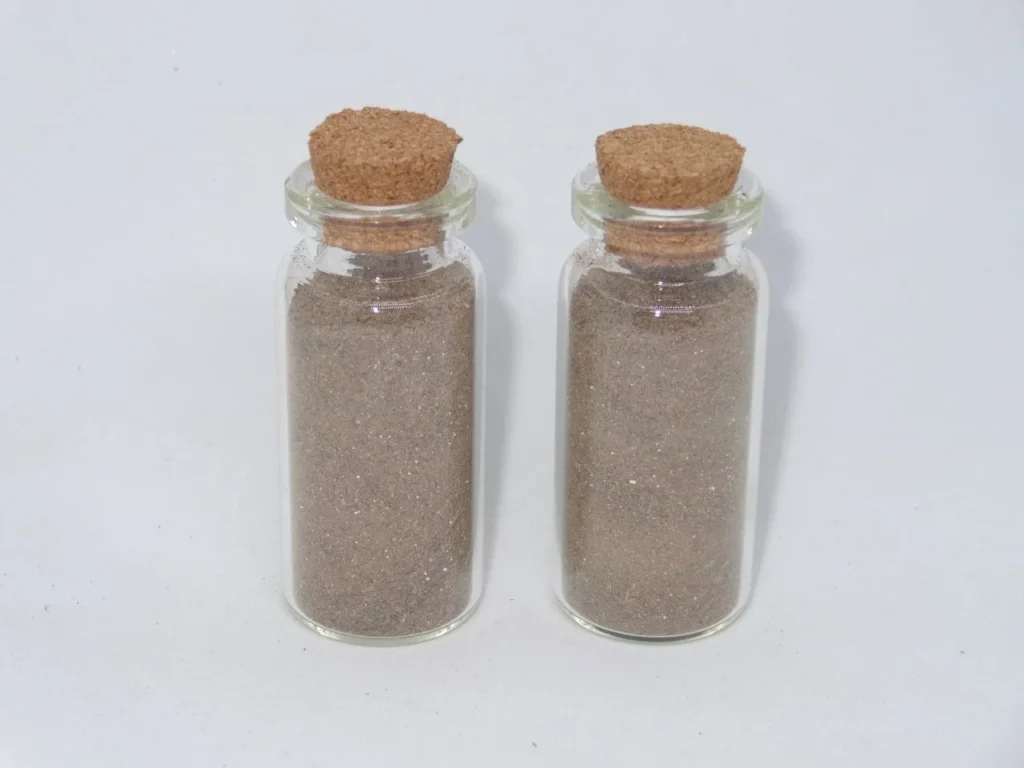 Dos frascos de vidrio con tapones de corcho y contenido en polvo